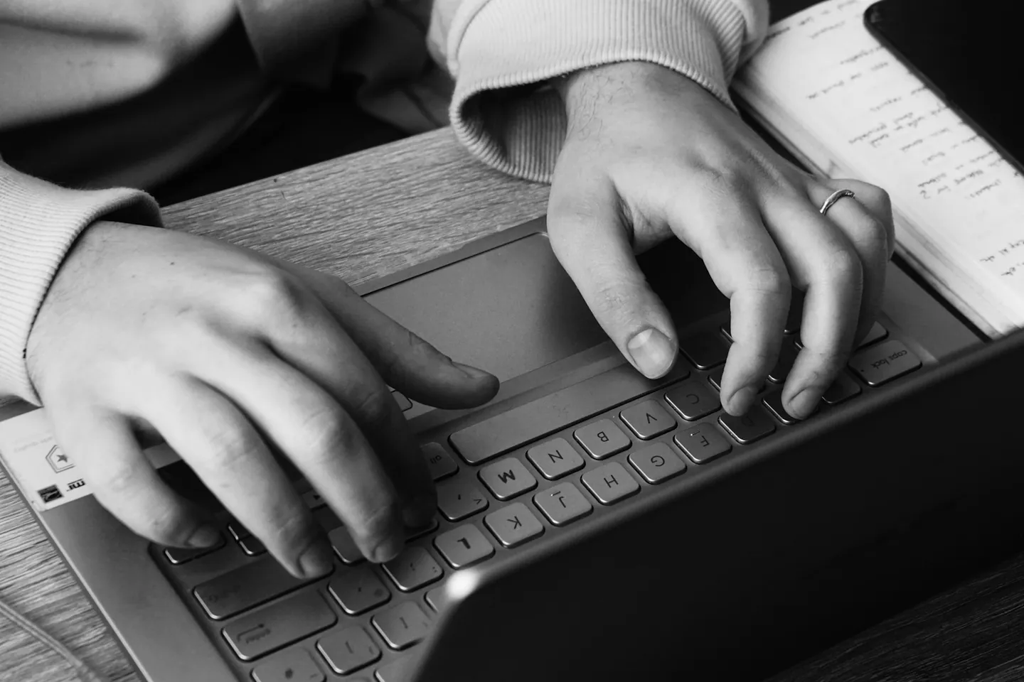 Hands working on a laptop at a desk