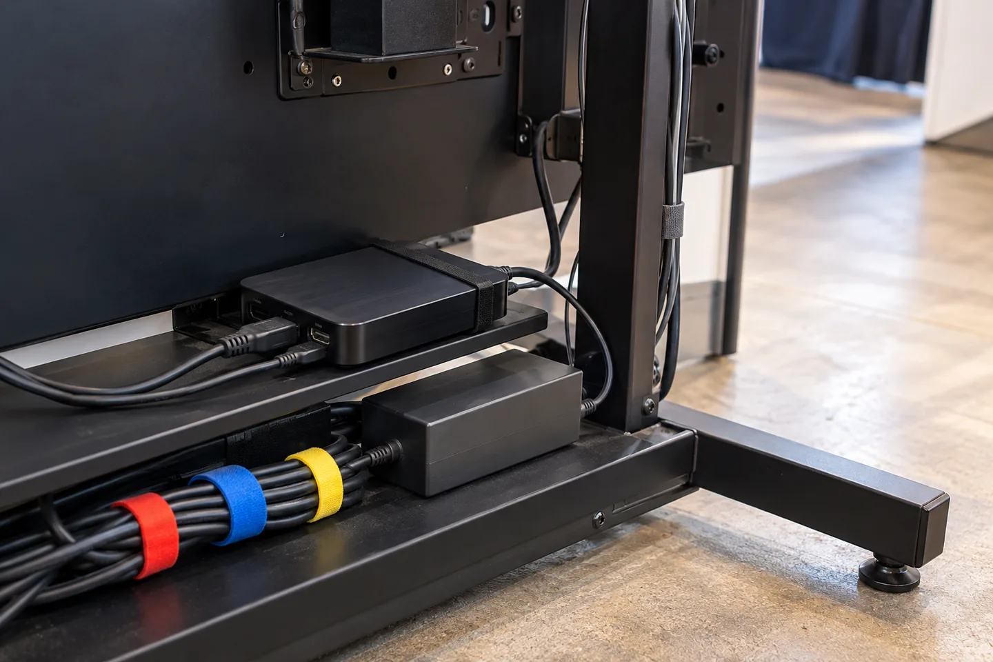 Media player, power adapter and labeled color-coded cable ties behind an exhibition display