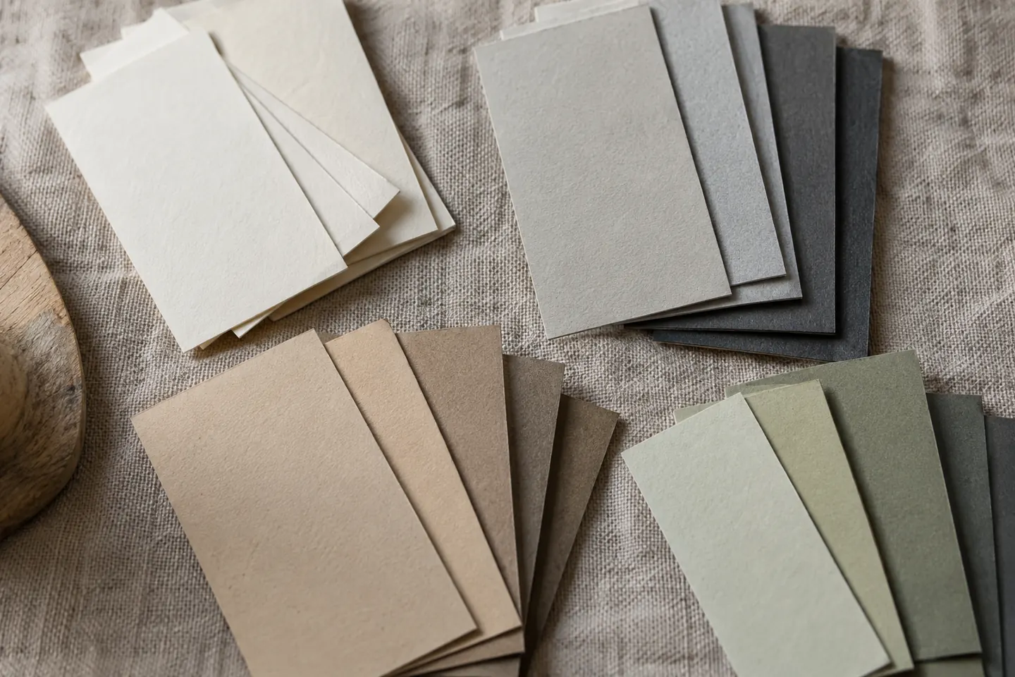 Overhead close-up of small neutral swatch cards sorted into distinct groups